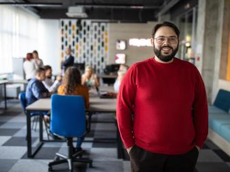Mann im roten Pulli steht in einem Büro