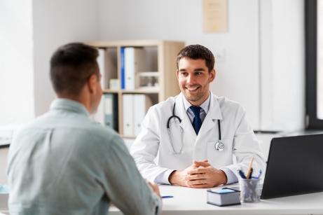 Gespräch zwischen Arzt und Patient am Schreibtisch
