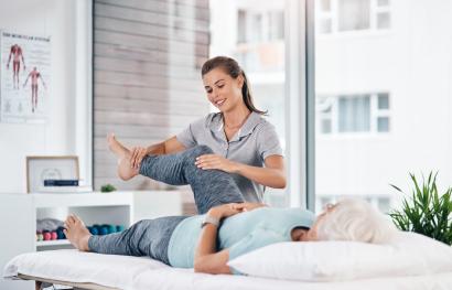 Ärztin bewegt das Bein der Patientin